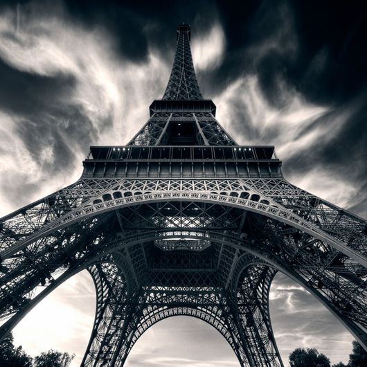 Фотообои Aim for the stars, Mr. Perswall с черно-белым изображением Эйфелевой башни, снятой с необычного ракурса. Заказать фотообои для стен в интернет-магазине, онлайн оплата.