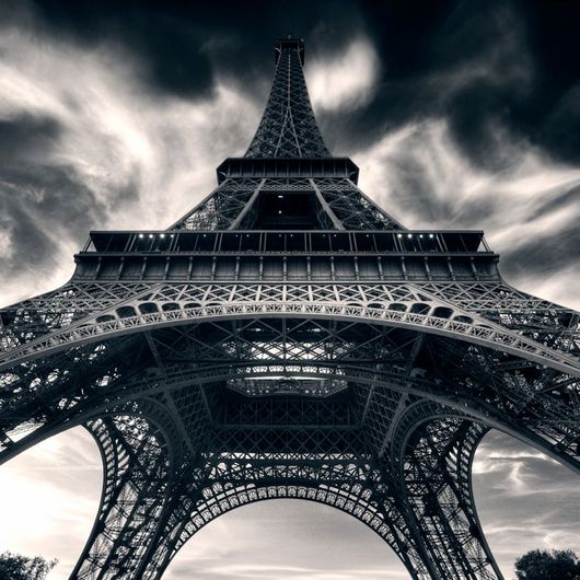 Фотообои Aim for the stars, Mr. Perswall с черно-белым изображением Эйфелевой башни, снятой с необычного ракурса. Заказать фотообои для стен в интернет-магазине, онлайн оплата.