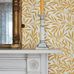 Фрагмент интерьера английского каминного зала задекорированного бумажными обоями  Willow  с акварельным растительным ретро узором ивовых листьев желтого цвета