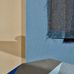 Фрагмент интерьера с однотонными рельефными обоями темно голубого цвета под ткань