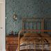 Интерьер винтажной спальни декорированный обоями Trädgårdsstaden, из каталога  "Alla Tiders Hus",  пастельно-голубого оттенка с зелеными, белыми и бледно-оранжевыми деталями — это поистине спокойный и классический стиль.