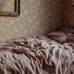 Интерьер спальни в скандинавском стиле с ретро обоями окрашенными теплую коричневую палитру с мелким рисунком цветущего шиповника.