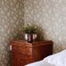 Интерьер спальни в скандинавском стиле с ретро обоями окрашенными теплую коричневую палитру с мелким рисунком цветущего шиповника.