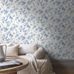 Интерьер гостиной с обоями Boråstapeter Blomslinga Blue&White (арт. 6146). Синие цветы и листья на фарфорово-белом фоне. Уютная усадебная обстановка с диваном, ротанговым столиком и пледом. Коллекция Blue & White от Boråstapeter.