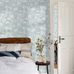 Интерьер скандинавской спальни декорированный обоями с рисунком NÄCKROS в оттенках голубого, бирюзы и белых, с вкраплениями охры, лилий.