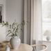 Обои флизелиновые "Vega" торжественно белого цвета с тонким глянцевым мерцанием в интерьере скандинавской гостиной со светлой мебелью.