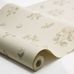 Фото рулона флизелиновых обоев Boråstapeter Luktärt Beige (арт. 8707). Полотно с узором с душистым горошком, фиалками, стрекозами и бабочками в мягких пастельных оттенках розового, зелёного и медово-жёлтого на кремово-белом фоне, свернутое в рулон на белом фоне. Коллекция Herrgård от Boråstapeter.