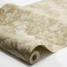 Фото рулона флизелиновых обоев Boråstapeter Alnarp Beige (арт. 8716). Полотно с пышным пейзажным узором с деревьями, рекой и мостом в тёплой бежевой палитре на светлом фоне, свернутое в рулон на белом фоне. Коллекция Herrgård от Boråstapeter.
