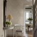 Интерьер коридора с флизелиновыми обоями Boråstapeter Hildasholm Beige (арт. 8722). Крупноцветковый узор с пионами, васильками, ландышами и другими местными растениями в белых тонах на светло-бежевом фоне. Элегантная усадебная обстановка с белым столиком, креслом, лампой, цветами и видом в столовую. Коллекция Herrgård от Boråstapeter.