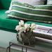 Фрагмент дивана в современном стиле на фоне обоев арт. 38606  из коллекции "Borosan EasyUp® 2020" от Borastapeter, Швеция с мелким растительным рисунком зеленого цвета на белом фоне