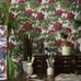 Живописный интерьер с живыми растениями и пышным цветочным узором на стене с обоями Bourlie от Cole & Son. Выбрать обои для гостиной, спальни в интернет-магазине, бесплатная доставка.