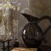 Фрагмент интерьера гостиной декорированной обоями  ELSIE из каталога " Шведская Грация" с цветочным узором из мерцающего золота по тонкому геометрическому темно-коричневому фону.