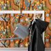 Флизелиновые обои из Швеции коллекция Scandinavian Designers II от Borastapeter, с завораживающим многоцветный сказочным рисунком на котором изображено множество различных деталей, сцен с людьми под названием Melodi на насыщенном оранжевом фоне.