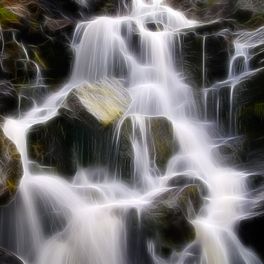 Фотопанно Fantasy waterfall с таинственным изображением сияющих потоков воды, низвергающихся по огромным зеленоватым валунам. Купить фотообои для стен в интернет-магазине, бесплатная доставка.